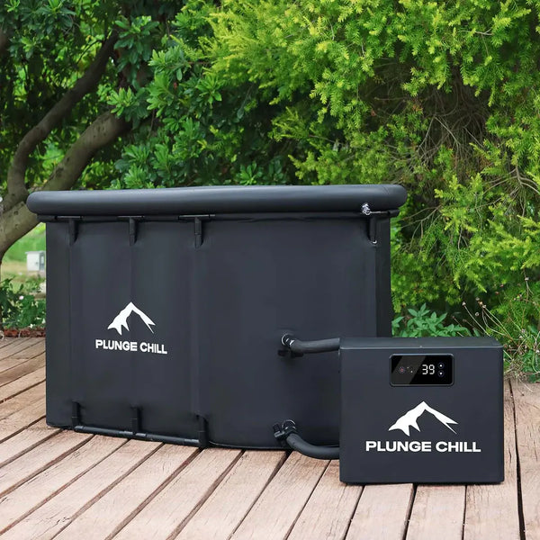 A black Plunge Chill tub and portable chiller unit on a wooden deck in front of green bushes.