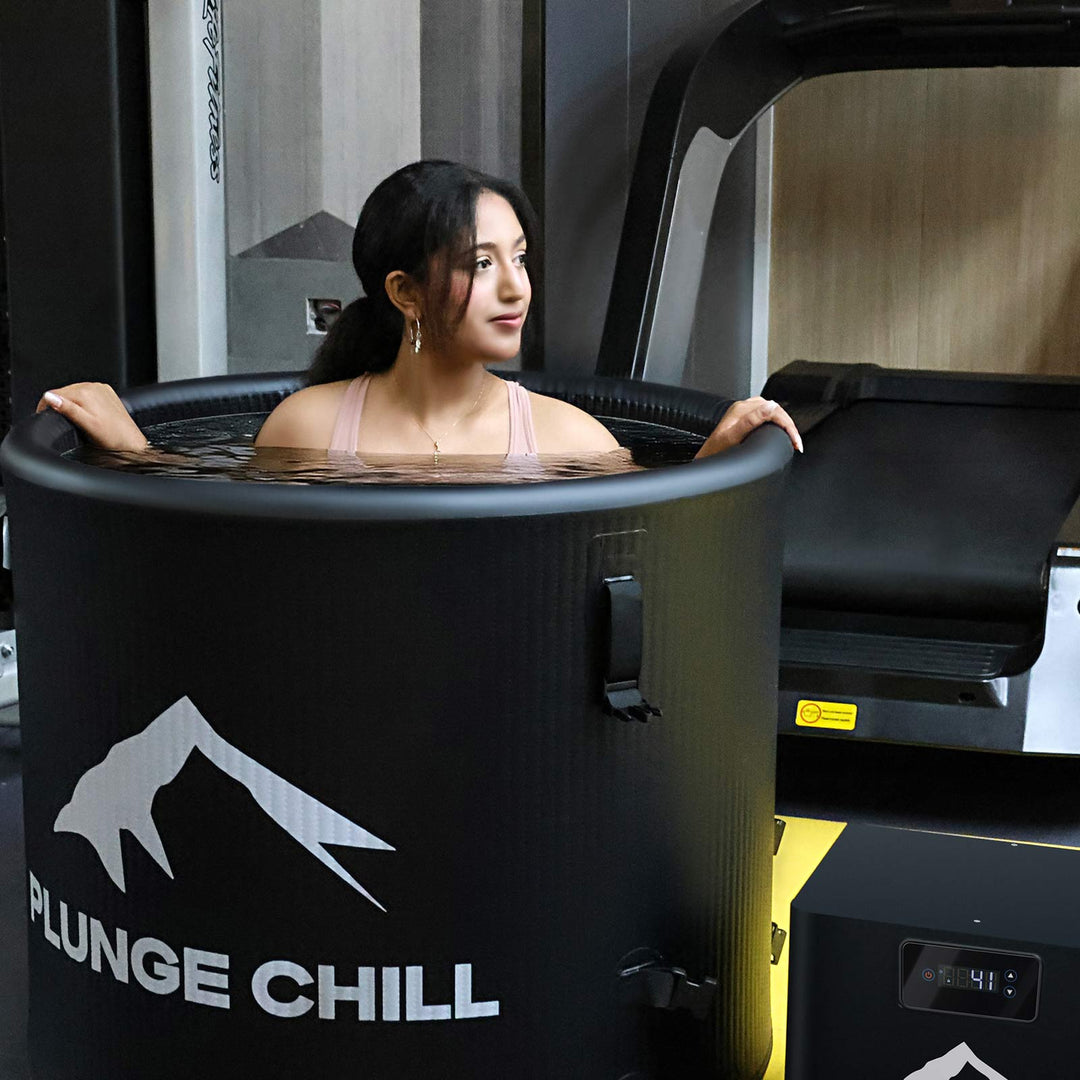 Man splashing water with joy while sitting in a Plunge Chill tub, embracing the moment.