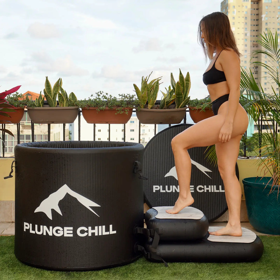 A woman is preparing to take an ice bath using a Plunge Chill ice tub.