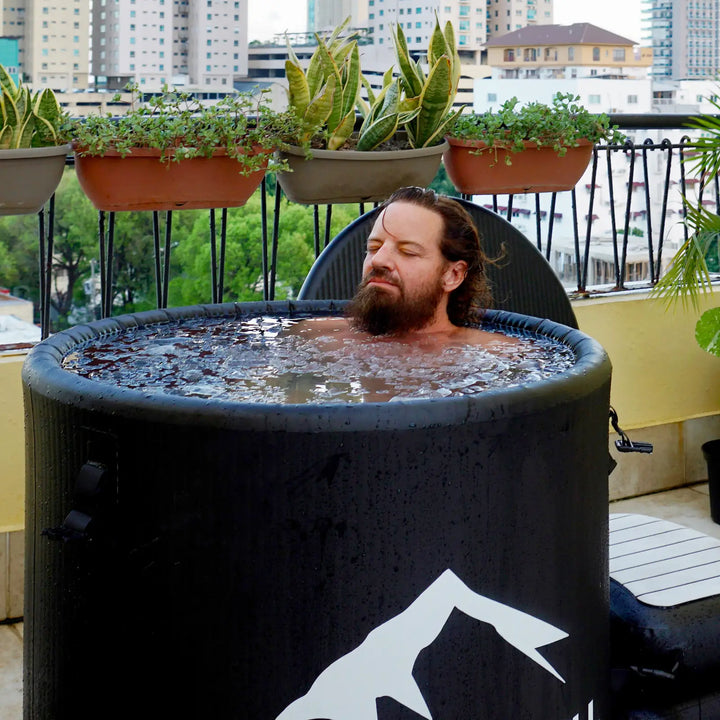 A man is taking a cold bath on the balcony of her home.