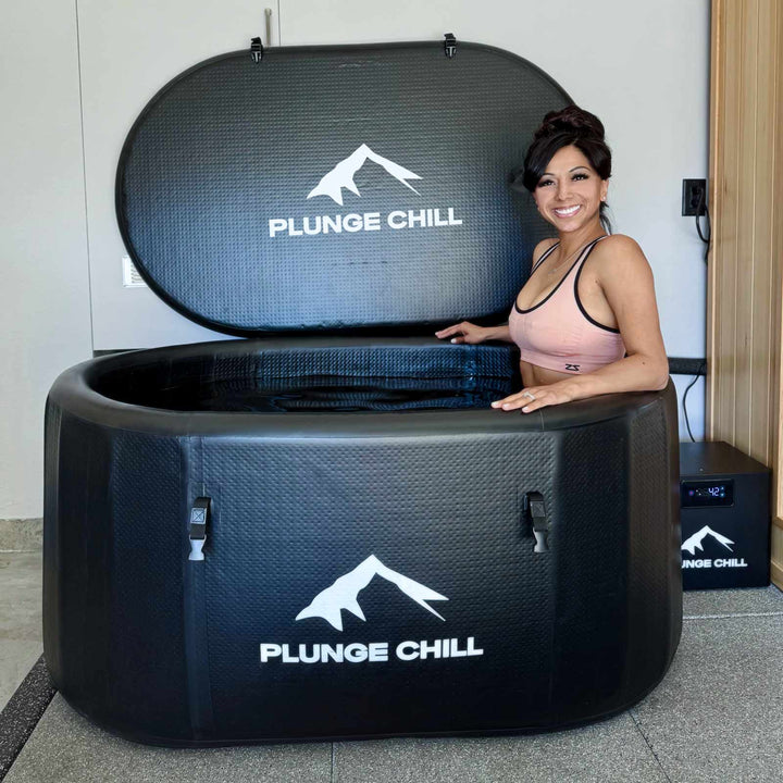 Woman smiling beside a durable inflatable cold plunge tub, enjoying a calm at-home cold plunge setup