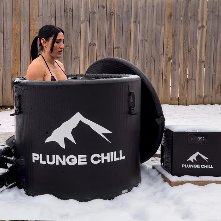 A women take a cold plunge in her yard when snowing with plunge chill tub and chiller