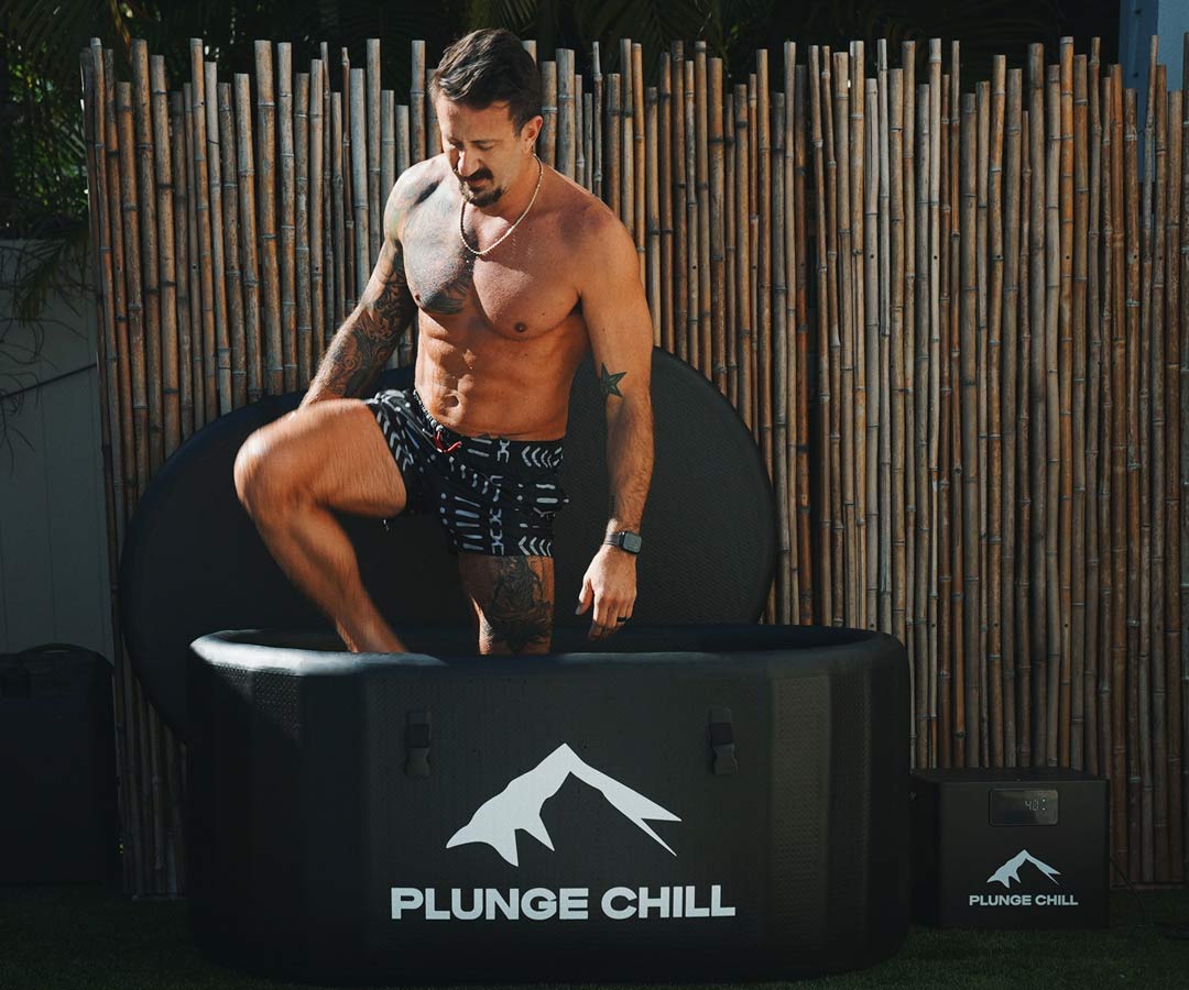 A man is taking a cold bath in a Plunge Chill cold plunge tub.
